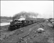 CBQ 4960, a 2-8-2 steam locomotive and a diesel helper with passenger cars east of Fromberg, MT.