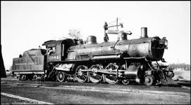 The engineer backs his Q Pacific to his train after taking water.  Althjough usually used on secondary passenger trains, it may be hard to guess what assignment this engine has drawn on a wartime day in spring.