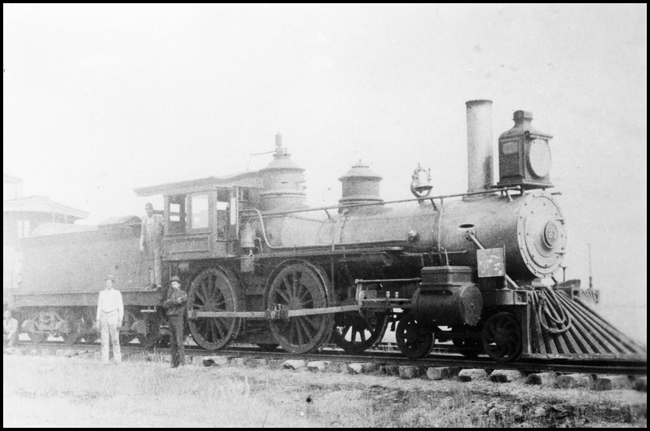 NP 23, a 4-4-0, at Blatchford, MT.  The engine was later numbered NP 829.   There are three engine crew member in the picture two on the ground and the third on cab walkway.