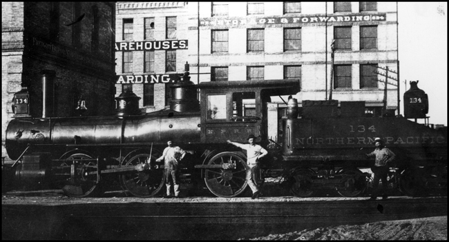 NP 134, a 0-6-0 switcher, at Minneapolis, MN. With three crewmen standing in front of the engine.  This engine was later number NP 967.