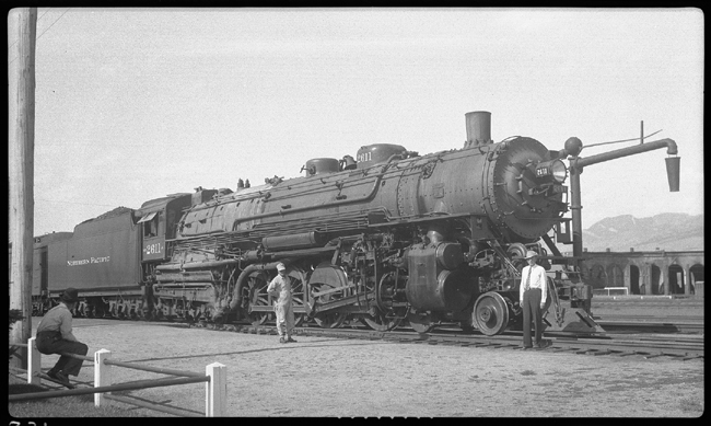 NP 2611, Class A on passenger train in Bozeman, MT with Bozeman roundhouse visible in background