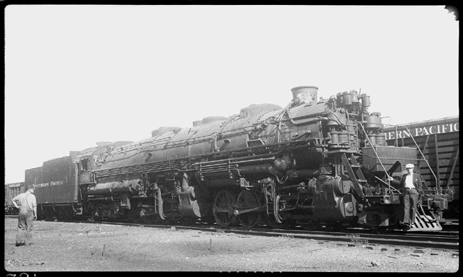 NP 5011, Class Z-5 at Livingston, MT with man standing on pilot and shop worker watching
