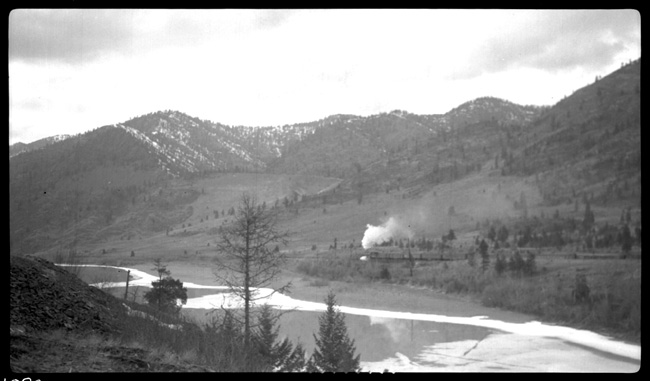 Rear of Train No. 1 with NP 2611, Class A going west after crossing Flathead River Bridge between Perma and Paradise, MT.