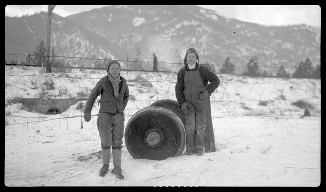 Unidentified people stand beside wheel assembly that is said to have a broken journal that caused wreck of Train No. 603 at Turah, MT. 