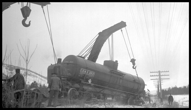Two wreckers picking up CONX 2631 which derailed in derailment of 19 cars from Train No. 603 at Turah, MT, MP 109.6, between Clinton and Bonner, MT