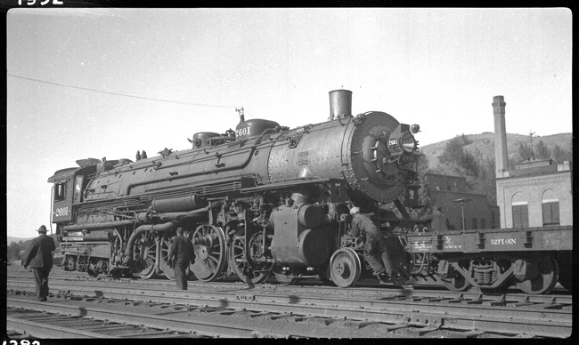 NP 2601, Class A coupled to flat car and back in terminal for repair, due to broken journal. Location for photo not given, but expect this is Livingston Back shop