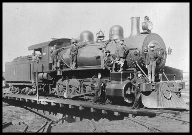 NP 41, Class Y, on turntable at Livingston Roundhouse with several workers standing on locomotive, posing for the picture. 