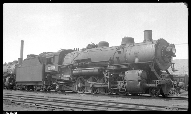NP 1730, Class W-3, on ready track east of Livingston roundhouse, with stationary stack on Livingston Back Shop in background.