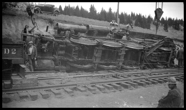 Wreck of NP 2215, Class Q-4, light engine West, with Engr. Adams and work X1562, Class W, at Homestake, MT, May 1930.  Wrecker rerailing  one locomotive.