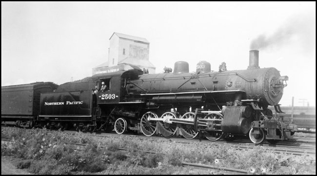 NP 2503, Class W-4 pulls passenger train past an elevator on the way out of Glendive.