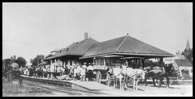 NP Depot at Fergus Falls, MN about 1906.  Horses, Wagons and drivers waiting.  NP 667, Class B locomotive in background.