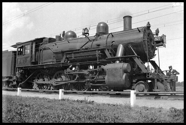 MILW 2627, 4-6-0 locomotive, obvious ready to go with a passenger run out of Three Forks, as Conductor checks his watch.