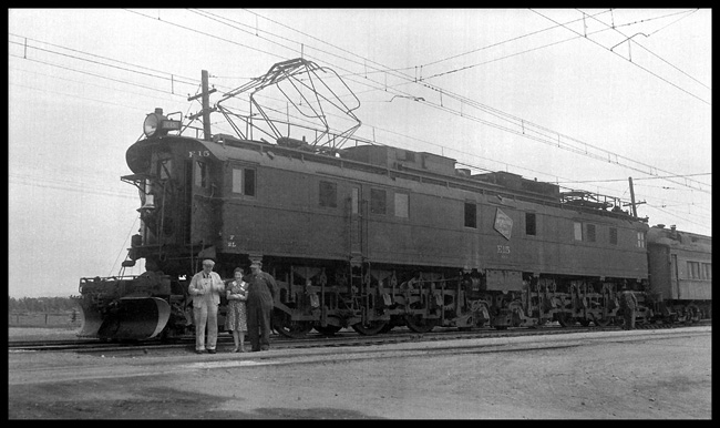 Proof that the well dressed engine crew on a mainline electrification dressed just like their brothers on the steam trains, and that they would also be ready for a picture with a pretty woman.  E-15 is a passenger unit, and it is at the business end of a train