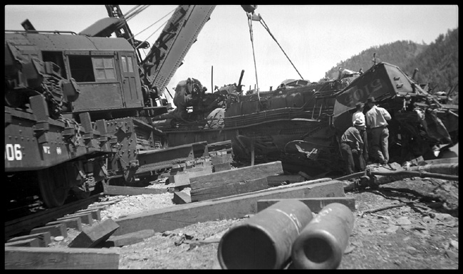 NP 5105 explosion  Willis, Mont. Same wreck as RVN01282. Views by M. W. Scott   Close-in shot of big hook lifting wreckage of 5105  Three unidentified workers in foreground