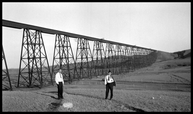 GN trestle near Minot  10/34 Low angle view of trestle, with two unknown men in suits posing for camera