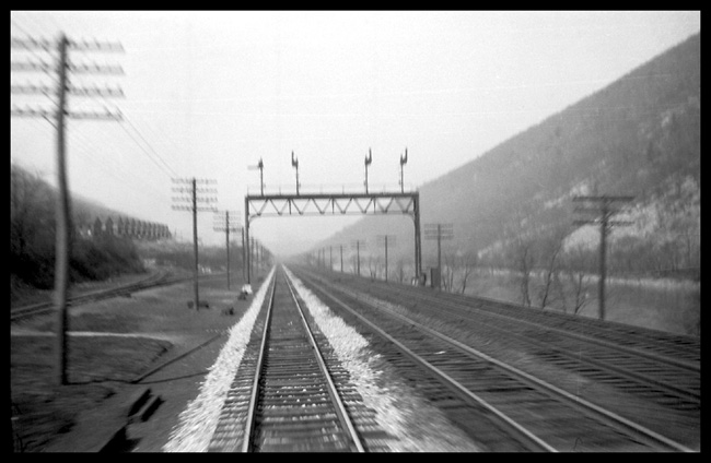 View of 4-track PRR siginal bridge from rear of train at speed between Altoona and Harrisburg, PA.