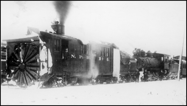 NP Rotary snow plow No. 6 handled by NP 97, Class F Consolidation locomotive and work train caboose moving snow at Wallace, ID. 