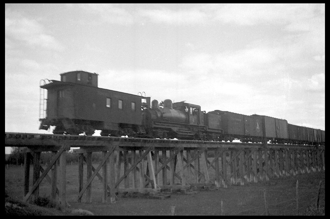 SLCo Extra 2 North  near Somers  6/39 LF low angle view of wood caboose, Shay #2 and a string of freight cars on a long, low wooden trestle