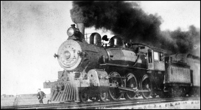 NP 218, Class P-1 pulls passenger train in Fargo area with someone running to throw a switch while fireman looks out the fireman's window.  Heavy black stack emission noted.