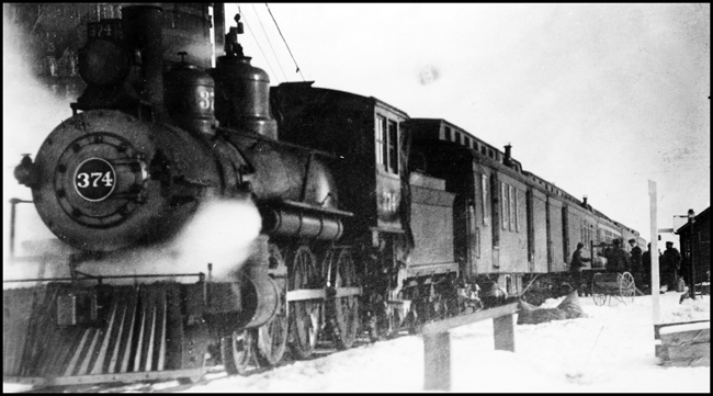 NP 374, Class E-2 locomotive on passenger train being serviced at Lenard, ND.