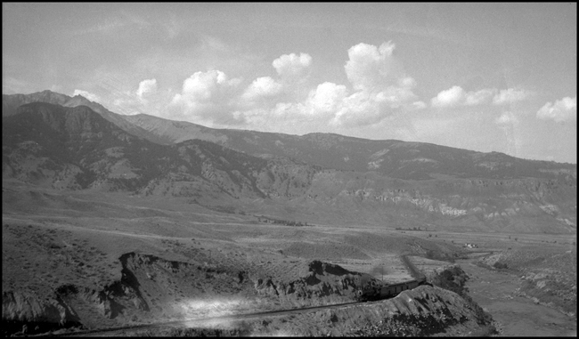 NP 217-1529  near Deevers  9/12/40  This view is of NP's passenger train from Livingston MT to the entrance to Yellowstone National Park at Gardiner  MT    1529 is a class W  2-8-2 built by ALCO in 1905 at their Brooks works  It is an oil burner, unusual on the Rocky Mountain Division, but deemed less conducive to fire setting than a coal-fired engine, a major consideration that close to Yellowstone Park  When the tourist season was over and wet weather returned to the area, 1529 would be transfered out to the Tacoma Division, where it saw service on the Grays Harbor branch  This was a recurring cycle of service for 1529  The river is the Yellowstone
