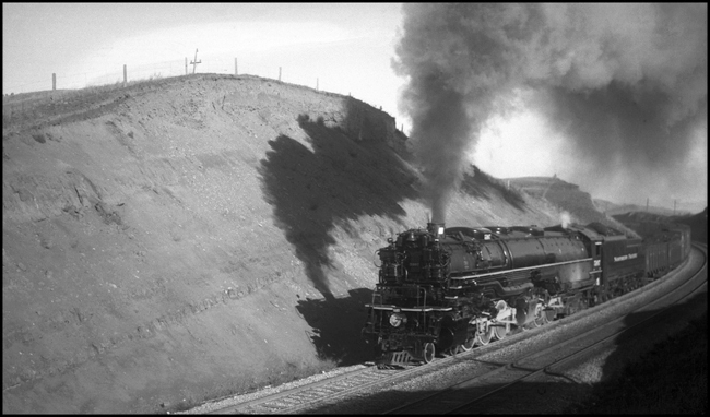 NP X5107W near Muir  11-01-1940  Ascending the eastern grade up toward Bozeman Tunnel over Bozeman Pass  This class Z-6 4-6-6-4 is a product of ALCO in 1937  The running gear shows its age, but the boiler and tender look as though they have been recently painted, probably at Livingston, which is the previous station on this trip  See RVN06481 for another view of this train