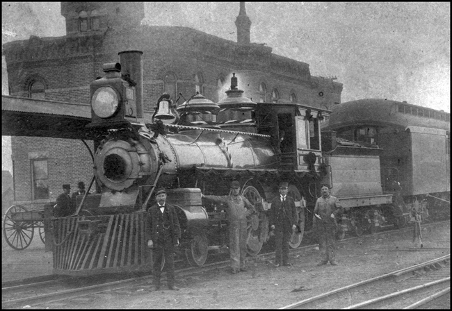Duplicate of RVNo6788, engine only  BA&P 50  Anaconda   Mont  1900  Regular BA&P train Anaconda to Butte decorated for a week due to death of Marcus Daley  Engineer Wilkins 3rd from right, only living member of crew  Copy negative from Wilkins  The cataloger does not know if this is the same Wilkins in the photo  If it is, then someone else took the shot.  This photo reminds us that the BA&P had steam, as well as electric, power.