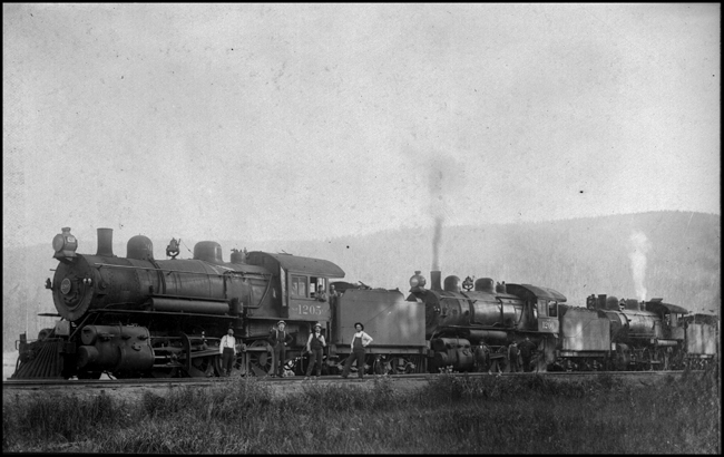 NP 1205-1200-1300 coupled  Evaro  Montana  about 1906  Copy negative from Moeller  Both 1200's are class Y-3 2-8-0's built in 1901 by Alco at Schenectady  The 1300 is a class S-3 4-6-0 also built in 1901 by Alco at Schenectady  These are probably helper engines that have been coupled together to form a single train on their return to their helper base  This makes the dispatcher's job much easier, as he needs to deal with just a single train rather than three separate trains.
