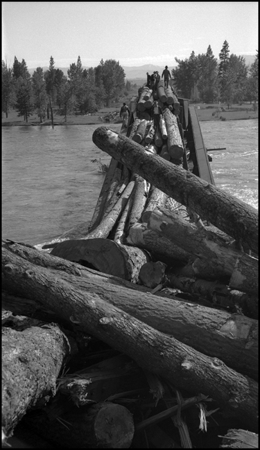 View of derailed log flats and bridge 23.2 were log train X1356E with 28 log cars derailed into the Bitter Root River caused by high water.  Killed Engr McFarland, Fmn Mc Gregor and Brkmn D'Orazi.