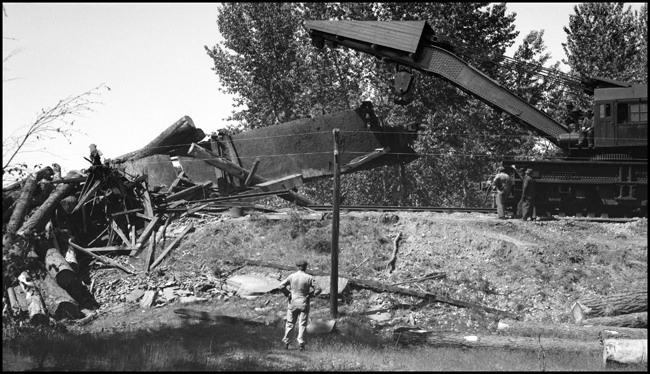 NP Wrecker 44 working on picking up wreck of log train X1356E with 28 log cars derailed into the Bitter Root River caused by high water.  Killed Engr McFarland, Fmn Mc Gregor and Brkmn D'Orazi.