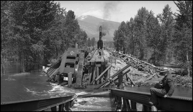 View of overturned NP Wrecker 45 resting on top of NP 1356 in water. Other wreckers could not lift Wrecker 45, so it had to be dismantled at the wreck site.