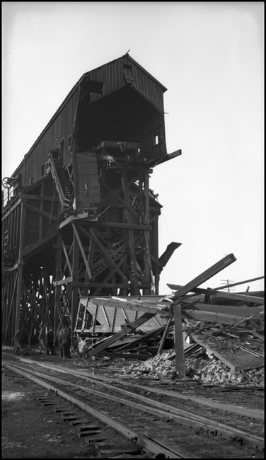 NP coal dock at Garrison after gondola had been pushed through end, falling to ground and crushing engine house.
