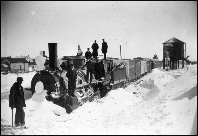 GN train snowed in at an unnamed location, showing workers shoveling out the stuck train.