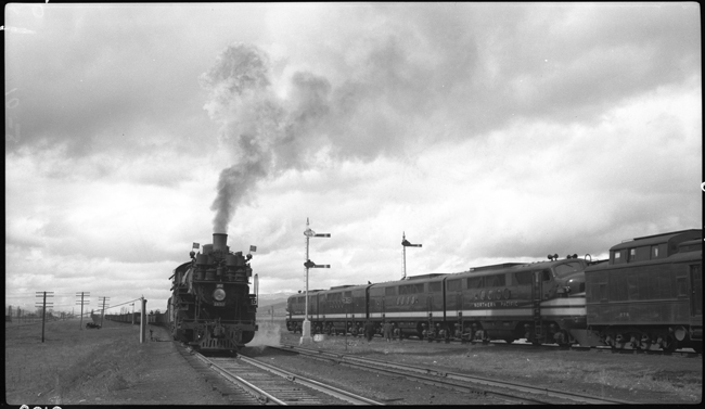 NP X1825E is passed by NP X6001W with Dynamometer Car NP 276 behind the power, while train moves out of Missoula Yard. 