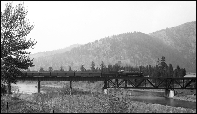 NP 2nd No. 2 pulled by NP 2666, Class A-3 Northern pulling the passenger cars over the bridge east of Missoula, near Bonner.