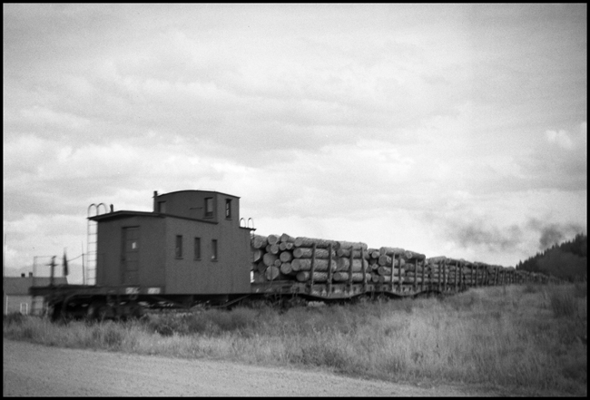 Somers Lumber Co. log train from rear, showing wood caboose, near Somers, MT.