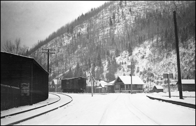 NP track, spur, grade crossing, Wallace, ID. Boxcar on siding.
