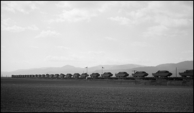 Landing craft on westbound NP freight extra pulled by 5117between Gaspard and Frenchtown, Montana enroute to the pacific theater of World War II, although labeled to go to Russia.