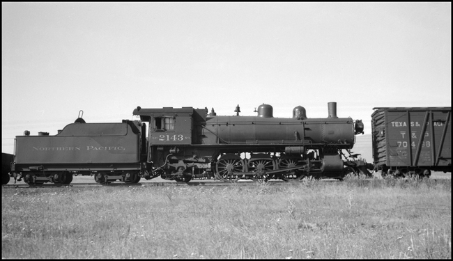 NP 2143, Class Q-1 locomotive with a wood sheathed box car following, as seen in Missoula.