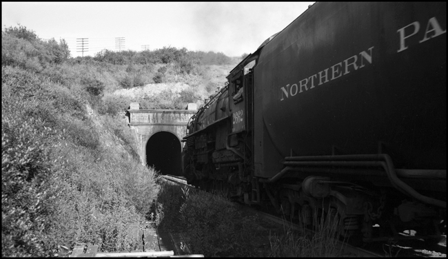 NP Train No. 1st No.1 with head end power NP 2662, Class A-3, conductor Weir, Engr Rugamer and on Helper engine NP 2246, Class Q-5, was Engr Pfohl handling 12 cars, entering old Bozeman tunnel just west of Muir.