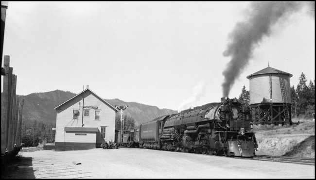 Extra 5140 East, powered by a Class Z-8 4-6-6-4, passes the Thompson Falls, Montana, depot. The train order signal displays 