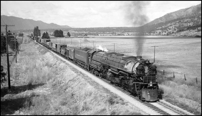 Extra 5140 East, powered by a Class Z-8 4-6-6-4, is about to pass under a highway bridge about one mile west of Woodlin, Montana.