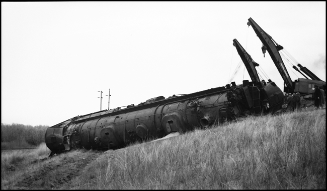 Second No. 3, an equipment special (deadheading Pullmans), derailed at 80 miles per hour on a 40 mile-per-hour curve, about a mile and a half east of Logan, Montana, on November 22, 1945, three days before this photo was taken. A second new 250-ton wrecker has joined the battle to retrieve the nearly 500-ton Class Z-8 4-6-6-4, no. 5132. This locomotive was repaired and returned to service.