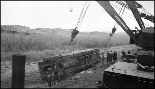 Second No. 3, an equipment special (deadheading Pullmans), derailed at 80 miles per hour on a 40 mile-per-hour curve, about a mile and a half east of Logan, Montana, on November 22, 1945, three days before this photo was taken. Two new 250-ton wreckers work together to retrieve the tender of Class Z-8 4-6-6-4 no. 5132. The 
