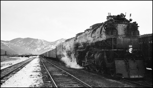 NP Extra 5141 West prepares to depart Missoula, Montana. The engine is a Class Z-8 4-6-6-4 built by Alco in March 1943. The crew: Engineer Otto C. Behner; Fireman M. H. Slenes; Conductor Byron W. Jenison; and Brakemen T. L. Sparks and L. N. Olsen. Engineer Behner is the oldest among these men, having been hired as a fireman in June 1908 and promoted to engineer in October 1917. The youngest is Olsen, hired as a brakeman in February 1937. Ron Nixon rode in the cab with the engine crew to Paradise so as to obtain publicity photos of a string of new refrigerator cars that were in the train. Ron had permission to stop the train anywhere he wished for this purpose. The series of photos of this train between Missoula and Paradise were the results of his effort.