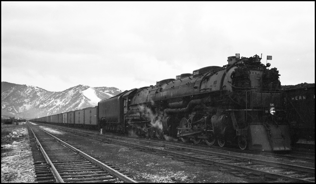 NP Extra 5141 West prepares to depart Missoula, Montana. The crew: Engineer Otto C. Behner; Fireman M. H. Slenes; Conductor Byron W. Jenison; and Brakemen T. L. Sparks and L. N. Olsen. Engineer Behner is the oldest among these men, having been hired as a fireman in June 1908 and promoted to engineer in October 1917. The youngest is Olsen, hired in February 1937. Ron Nixon rode in the cab with the engine crew to Paradise so as to obtain publicity photos of a string of new refrigerator cars that were in the train. Ron had permission to stop the train anywhere he wished for this purpose. The series of photos of this train between Missoula and Paradise were the results of his effort.