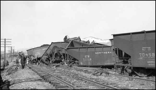 Extra 5121 West rear-ended the main line local, Extra 1816 West, at Drummon, MT. This accident resulted indirectly from the events surrounding the derailment of wrecker 47 east of Missoula (see RVN09581-09595). Missoula engineer Charles F. Reinke and his fireman had been on a layover in Helena when they were called to take Helena wrecker no. 37 to Missoula to help re-rail wrecker 47. In the meantime, officials decided to use a small wrecker from the Missoula car shop to assist wrecker 27 for that job, so Reinke and his fireman were stopped at Garrison and sent back to Helena. Then, after returning to Helena, they were called short of their legal rest period to handle Extra 5121 West. According to railroad officials, as Reinke approached Drummond he and his fireman had probably fallen asleep and missed block signals protecting the rear of Extra 1816 West. Extra 1816 West's conductor looked out the back of his caboose just in time to see the high speed approach of Extra 5121 West, so he ran into the nearby field. His brakemen were already on the ground giving signals for switching moves they were making at Drummond. The big Z-7 4-6-6-4 type locomotive plowed into the local's wooden caboose at high speed. There were only minor injuries to the crews involved. Conductor Emil Berglin was in charge of Extra 5121 West. Engineer Elmer Walkup and Conductor Malcom McCauley were handling the local.