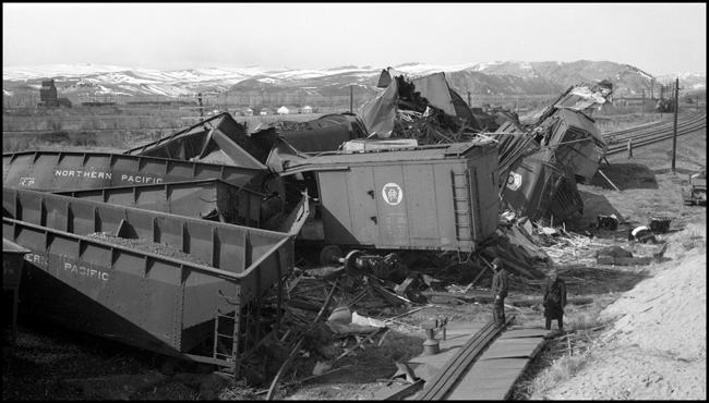 Extra 5121 West rear-ended the main line local, Extra 1816 West, at Drummon, MT. This accident resulted indirectly from the events surrounding the derailment of wrecker 47 east of Missoula (see RVN09581-09595). Missoula engineer Charles F. Reinke and his fireman had been on a layover in Helena when they were called to take Helena wrecker no. 37 to Missoula to help re-rail wrecker 47. In the meantime, officials decided to use a small wrecker from the Missoula car shop to assist wrecker 27 for that job, so Reinke and his fireman were stopped at Garrison and sent back to Helena. Then, after returning to Helena, they were called short of their legal rest period to handle Extra 5121 West. According to railroad officials, as Reinke approached Drummond he and his fireman had probably fallen asleep and missed block signals protecting the rear of Extra 1816 West. Extra 1816 West's conductor looked out the back of his caboose just in time to see the high speed approach of Extra 5121 West, so he ran into the nearby field. His brakemen were already on the ground giving signals for switching moves they were making at Drummond. The big Z-7 4-6-6-4 type locomotive plowed into the local's wooden caboose at high speed. There were only minor injuries to the crews involved. Conductor Emil Berglin was in charge of Extra 5121 West. Engineer Elmer Walkup and Conductor Malcom McCauley were handling the local.
