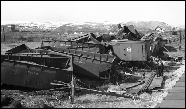 Extra 5121 West rear-ended the main line local, Extra 1816 West, at Drummon, MT. This accident resulted indirectly from the events surrounding the derailment of wrecker 47 east of Missoula (see RVN09581-09595). Missoula engineer Charles F. Reinke and his fireman had been on a layover in Helena when they were called to take Helena wrecker no. 37 to Missoula to help re-rail wrecker 47. In the meantime, officials decided to use a small wrecker from the Missoula car shop to assist wrecker 27 for that job, so Reinke and his fireman were stopped at Garrison and sent back to Helena. Then, after returning to Helena, they were called short of their legal rest period to handle Extra 5121 West. According to railroad officials, as Reinke approached Drummond he and his fireman had probably fallen asleep and missed block signals protecting the rear of Extra 1816 West. Extra 1816 West's conductor looked out the back of his caboose just in time to see the high speed approach of Extra 5121 West, so he ran into the nearby field. His brakemen were already on the ground giving signals for switching moves they were making at Drummond. The big Z-7 4-6-6-4 type locomotive plowed into the local's wooden caboose at high speed. There were only minor injuries to the crews involved. Conductor Emil Berglin was in charge of Extra 5121 West. Engineer Elmer Walkup and Conductor Malcom McCauley were handling the local.