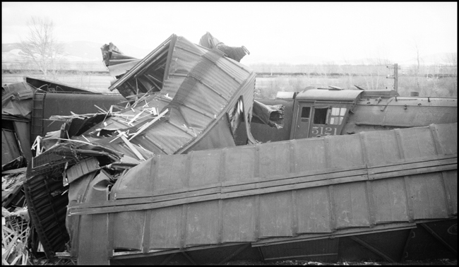 Extra 5121 West rear-ended the main line local, Extra 1816 West, at Drummon, MT. This accident resulted indirectly from the events surrounding the derailment of wrecker 47 east of Missoula (see RVN09581-09595). Missoula engineer Charles F. Reinke and his fireman had been on a layover in Helena when they were called to take Helena wrecker no. 37 to Missoula to help re-rail wrecker 47. In the meantime, officials decided to use a small wrecker from the Missoula car shop to assist wrecker 27 for that job, so Reinke and his fireman were stopped at Garrison and sent back to Helena. Then, after returning to Helena, they were called short of their legal rest period to handle Extra 5121 West. According to railroad officials, as Reinke approached Drummond he and his fireman had probably fallen asleep and missed block signals protecting the rear of Extra 1816 West. Extra 1816 West's conductor looked out the back of his caboose just in time to see the high speed approach of Extra 5121 West, so he ran into the nearby field. His brakemen were already on the ground giving signals for switching moves they were making at Drummond. The big Z-7 4-6-6-4 type locomotive plowed into the local's wooden caboose at high speed. There were only minor injuries to the crews involved. Conductor Emil Berglin was in charge of Extra 5121 West. Engineer Elmer Walkup and Conductor Malcom McCauley were handling the local.